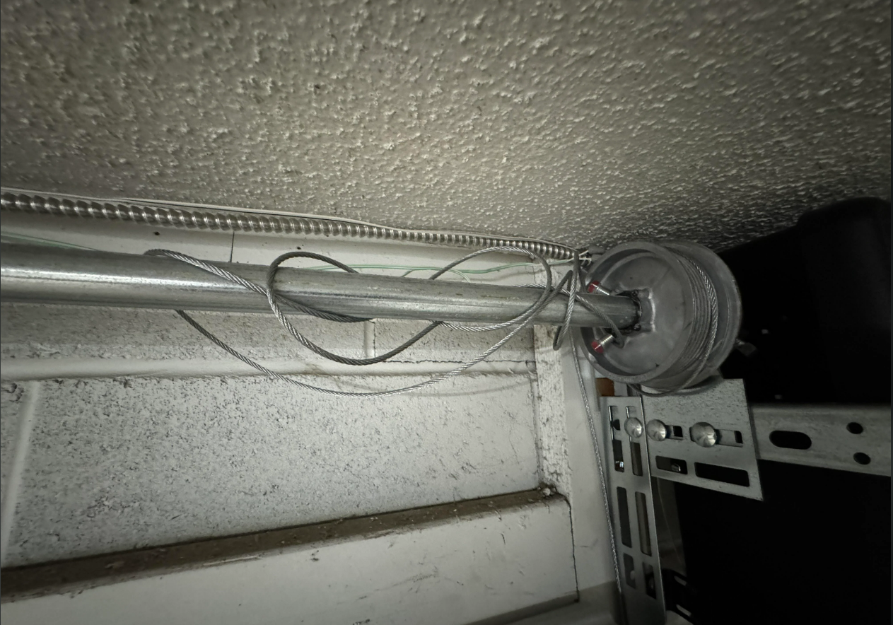 Close-up of technician performing garage door cable repair in Fort Pierce, FL, ensuring safety and functionality for residential properties.