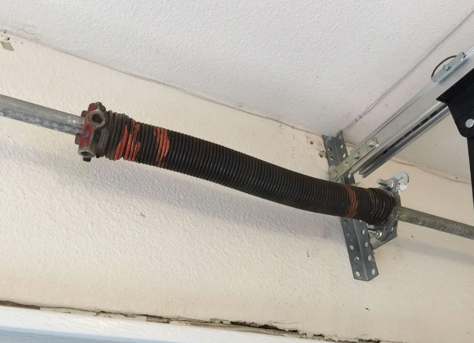 Technician performing garage door spring repair in Fort Pierce, FL for improved safety and functionality