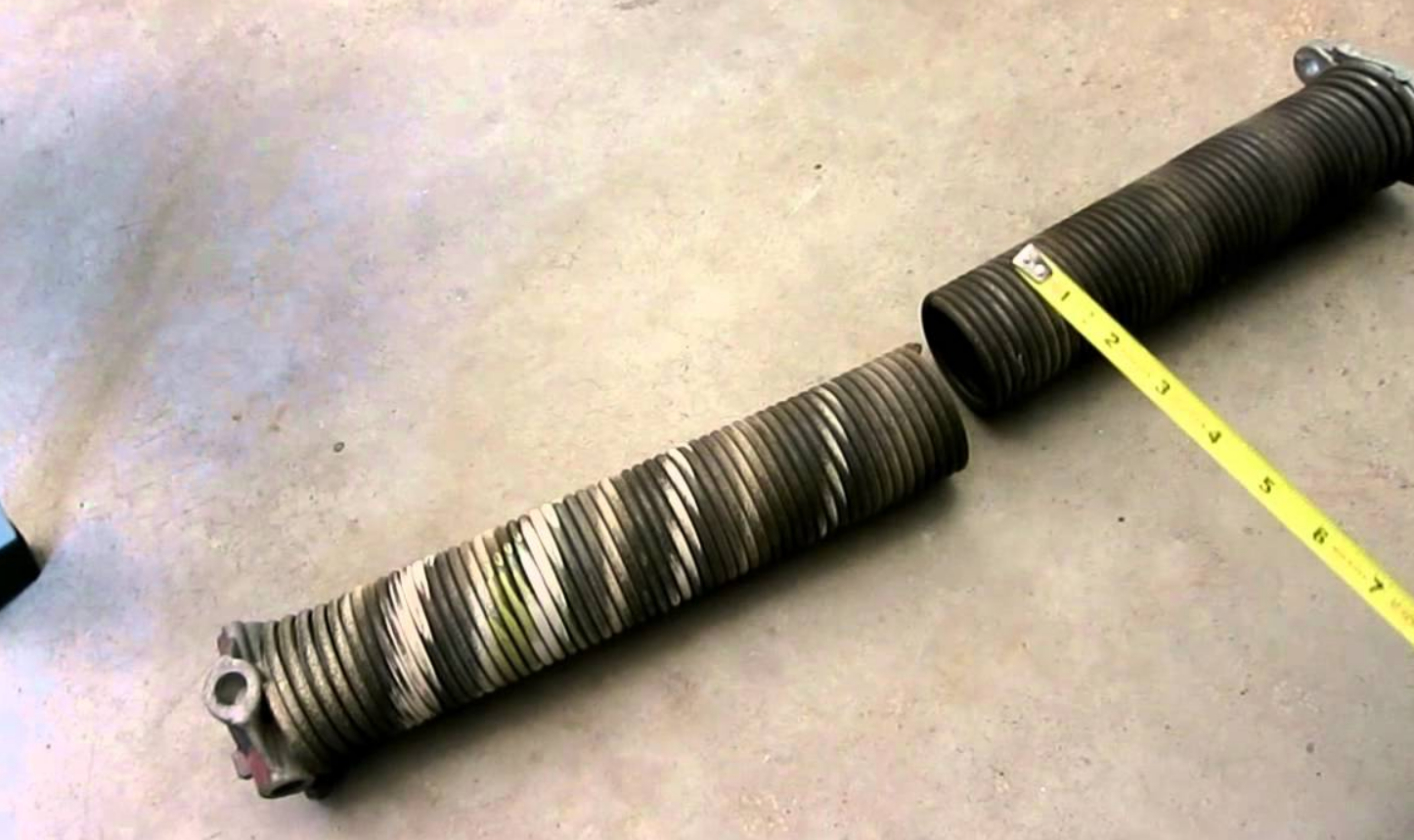 a technician repairing an overhead garage door spring in Fort Pierce, FL. The professional is carefully adjusting the spring with specialized tools to ensure the garage door functions smoothly and safely. Ideal for homeowners in need of reliable garage door spring repair services.