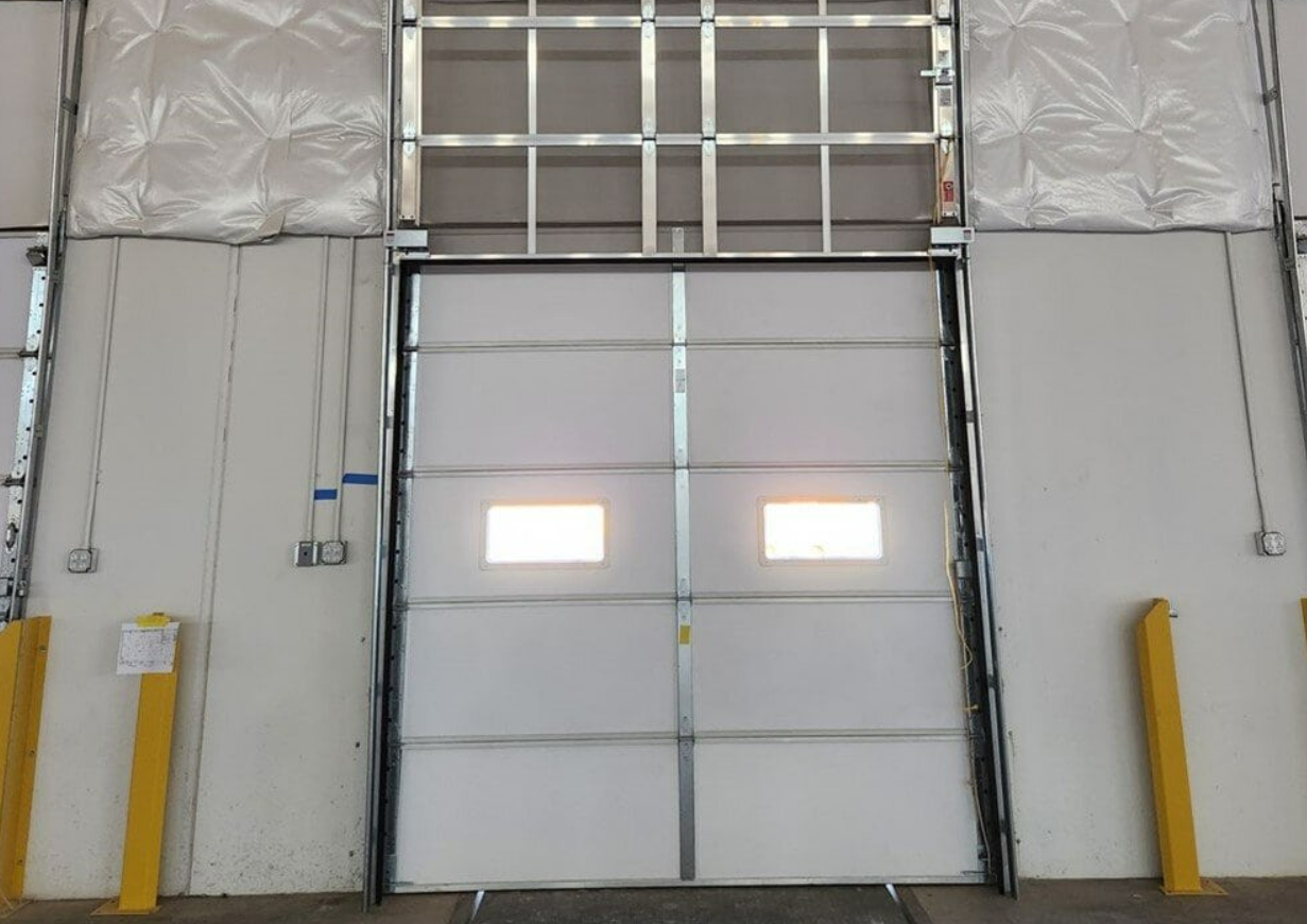 a professional technician diligently working on an overhead garage door repair in Fort Pierce, FL, focusing on ensuring the door functions smoothly and safely.