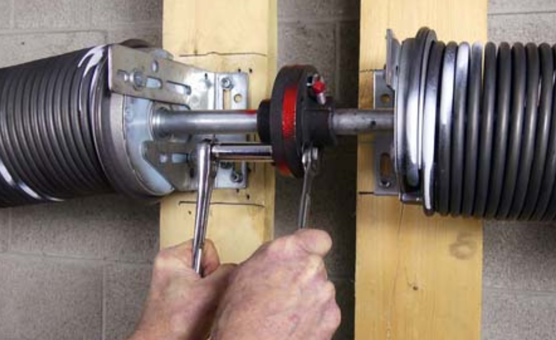 a professional technician fixing a broken garage door spring with specialized tools in Fort Pierce, FL, showcasing expert repair services for residential garages.