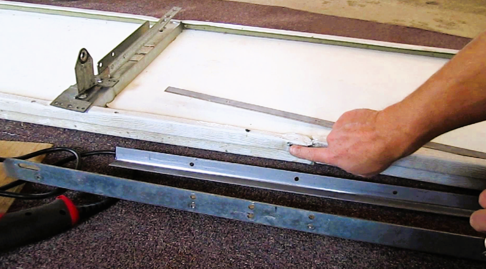 a technician fixing a garage door panel in Fort Pierce, FL, showcasing professional garage door repair services specializing in garage door panel repair.