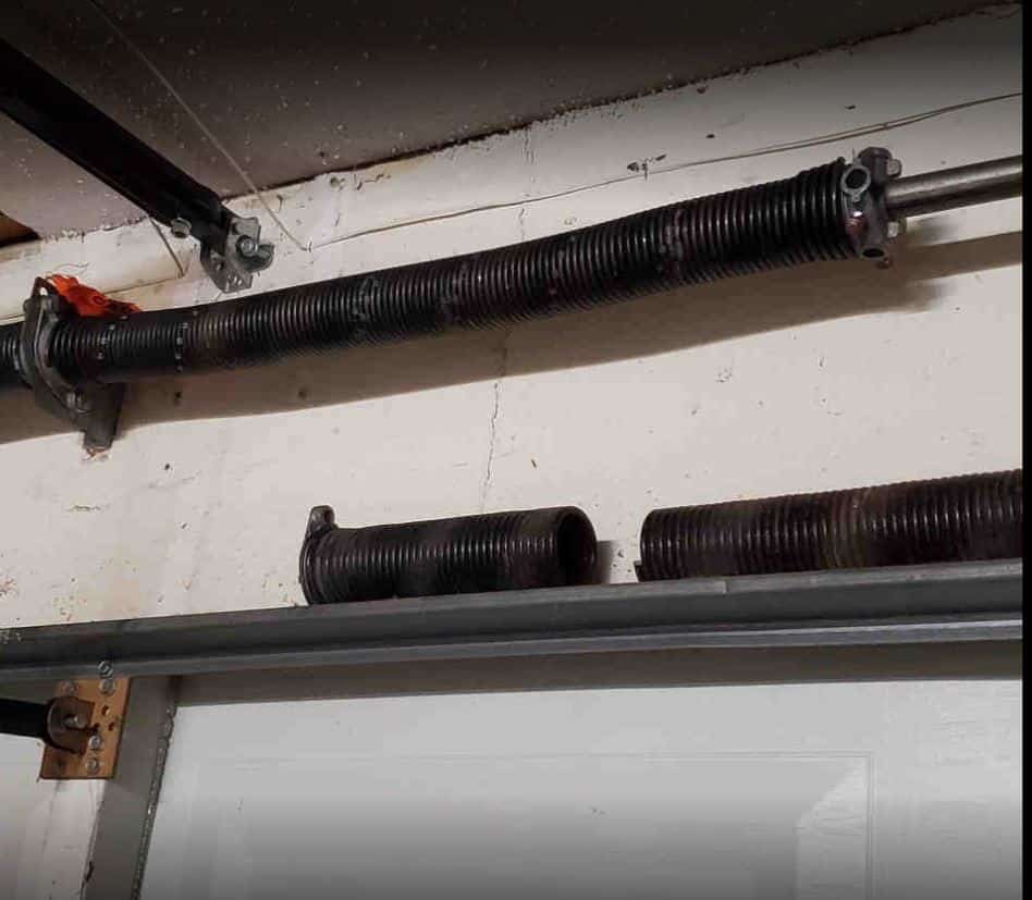 "Close-up image of a technician performing garage door spring repair, showcasing tools and equipment used in Fort Pierce, FL. Ideal for illustrating professional garage door repair services.